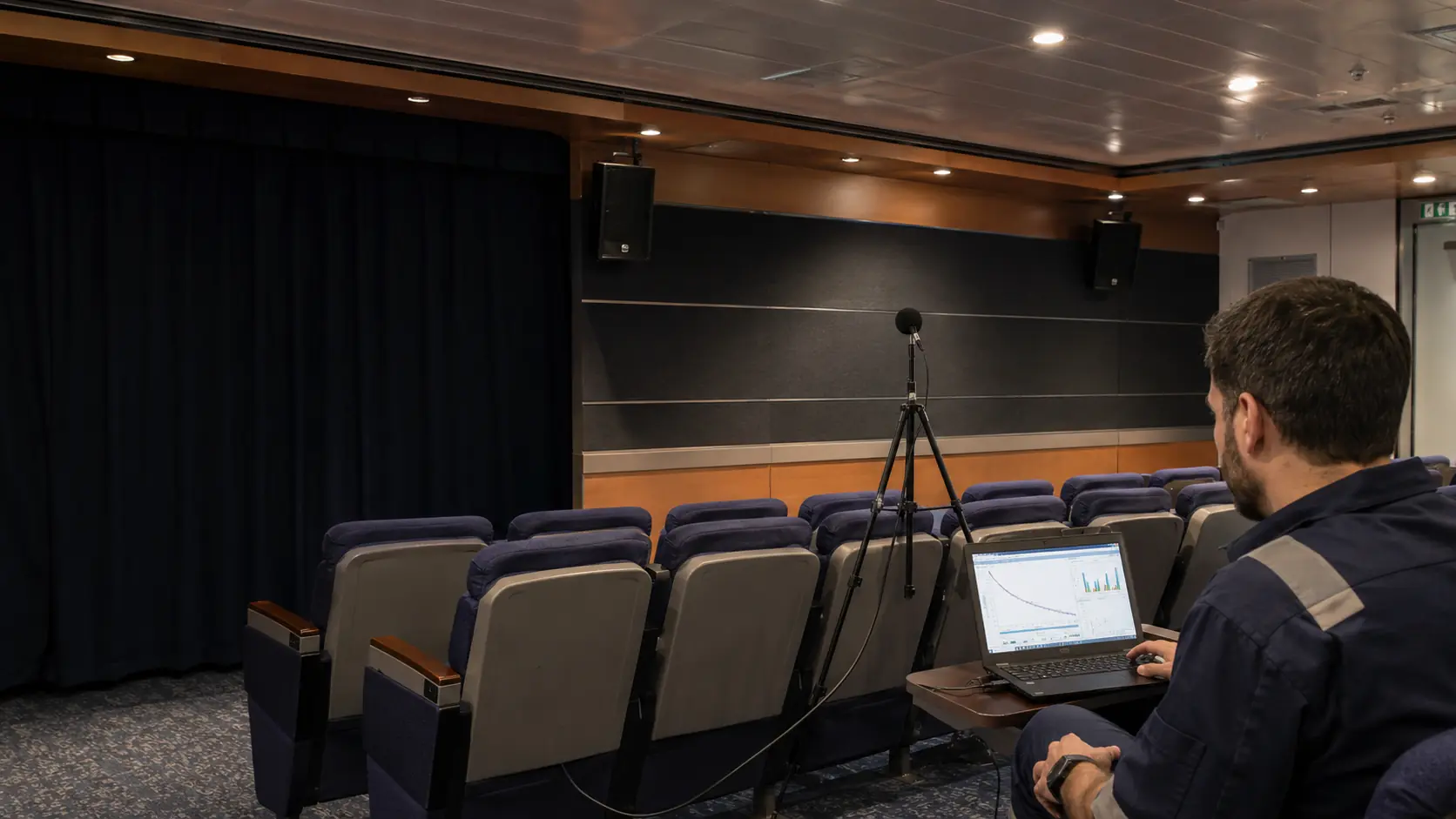 Marine acoustic technician analysing reverberation decay in an onboard vessel theatre